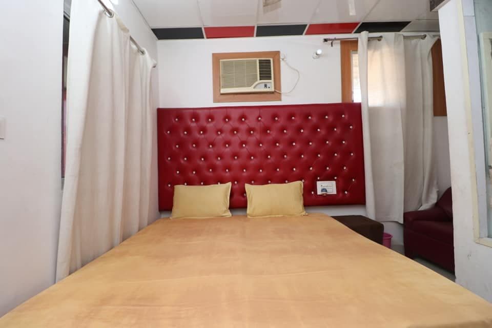Guest room with double bed beside a curtained window